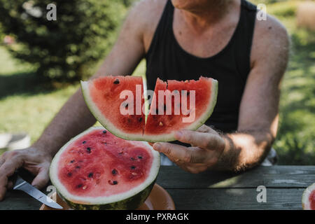 Die Hand des älteren Mann mit Wassermelone Slice Stockfoto