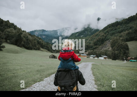 Österreich, Vorarlberg, Mellau, Mutter mit Kleinkind auf den Schultern auf einer Reise in die Berge Stockfoto