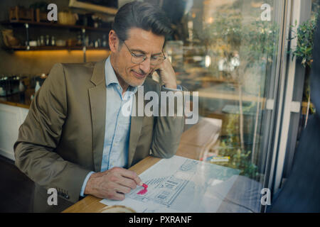 Reifen Geschäftsmann im Café sitzen, Zeichnung Umriss eines Hauses Stockfoto