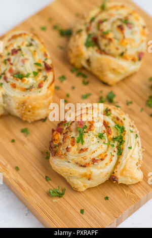 Sticky Buns mit Feta, Käse, Speck und Petersilie auf Holzbrett Stockfoto