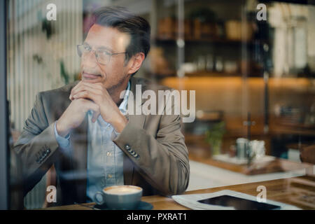 Reifen Geschäftsmann im Café sitzen, lächeln Stockfoto