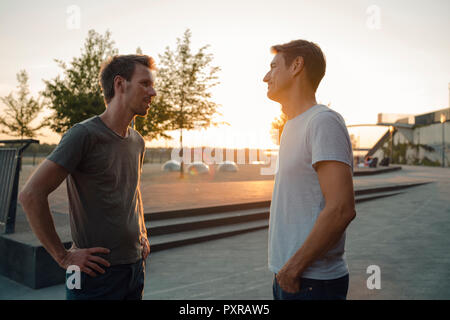 Zwei Freunde treffen bei Sonnenuntergang, am Abend reden Stockfoto