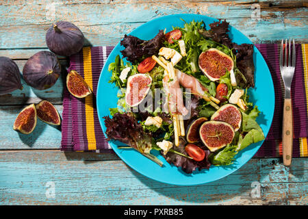 Gemischter Salat mit Feigen, Tomaten, Schafskäse, grissini mit Schinken auf Platte Stockfoto