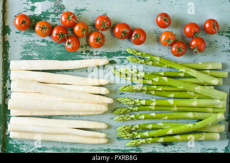 Raw weißen und grünen Spargelspitzen und Tomaten Stockfoto