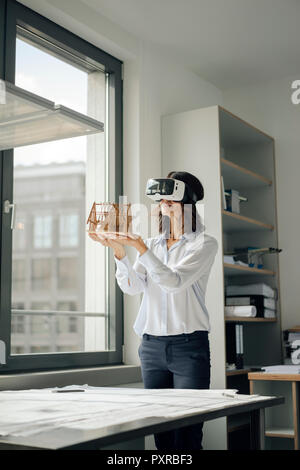 Frau mit architektonischen Modell des Hauses, mit VR-Brille Stockfoto