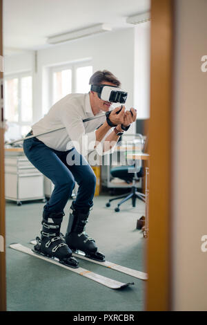 Geschäftsmann Skifahren im Büro, mit VR-Brille Stockfoto