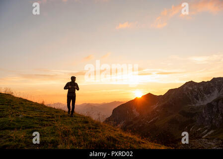 Deutschland, Bayern, Oberstdorf, Mann auf eine Wanderung in die Berge bei Sonnenuntergang Stockfoto