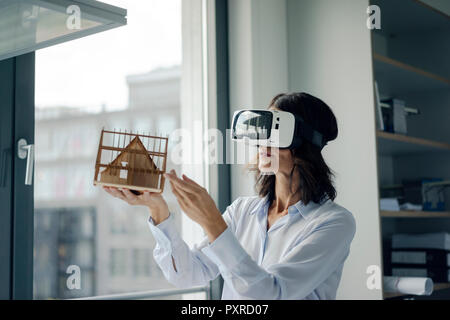Frau mit architektonischen Modell des Hauses, mit VR-Brille Stockfoto