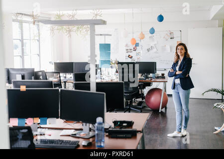 Zuversichtlich Geschäftsfrau ständigen lächelnd im Büro Stockfoto