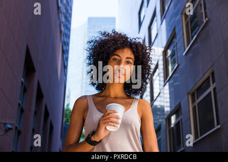 Deutschland, Frankfurt, Porträt der jungen Frau mit Kaffee in die Stadt zu gehen Stockfoto