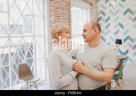 Abendessen mit der Familie. Familie empfängt Gäste, ein festliches Meeting. Gerne Reifes Paar, Mann und Frau Stockfoto