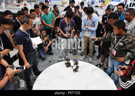 Shunde, China Guangdong Provinz. 24 Okt, 2018. Besucher beobachten Roboter in Boxen zu 20 nationalen Roboter und künstliche Intelligenz Wettbewerb in Shunde Bezirk von Foshan, des südchinesischen Provinz Guangdong, Okt. 24, 2018 konkurrieren. Die 20 nationalen Roboter und künstliche Intelligenz Wettbewerb startete hier am Mittwoch. Mehr als 200 Teams aus 78 chinesischen Hochschulen an 49 Wettkämpfen unter 13 Kategorien. Credit: Sadat/Xinhua/Alamy leben Nachrichten Stockfoto