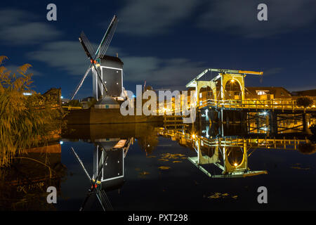 Mühle de Setzen und das rembrandt Brücke in Leiden in der Nacht und Reflexion in den Fluss Rhein in Leiden, Niederlande Stockfoto