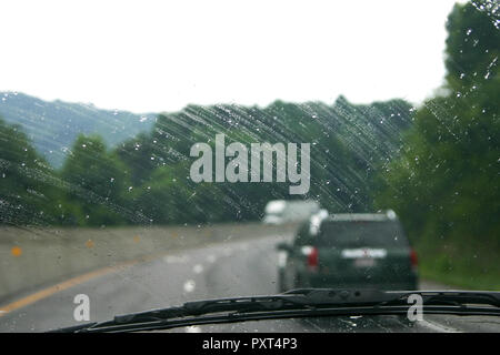 Nasse reisen Fahrt auf Autobahn wie gesehen, durch einen regen Windschutzscheibe bei schlechtem Wetter an einem regnerischen Tag gespritzt Stockfoto