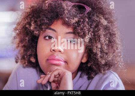 Portrait von Curly behaarte Frauen, die bei Camera suchen Stockfoto