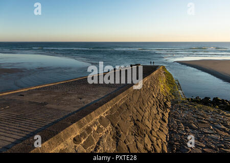 Zwei Jungen stehen am Rand der Stein rock Rampe in St. Ouen's Bay in englischer Kanal Jersey führenden an sonnigen Sommernachmittag Stockfoto