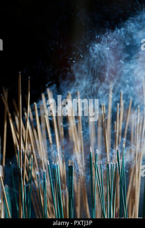 Rauch von Räucherstäbchen in einem Tempel Räuchergefäß durch Sonnenlicht beleuchtet. Kyoto, Japan. Stockfoto