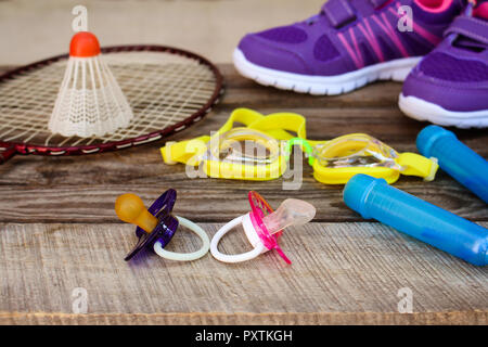 Sport Ausstattung: Das Birdie ist auf dem Schläger, Springseil, Schwimmbrille und Sneakers an Holz- Hintergrund Stockfoto