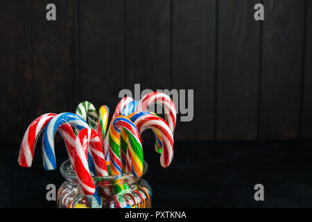 Bunte Weihnachten Zuckerstangen in Glas Glas auf Holz- Hintergrund mit Kopie Raum Stockfoto