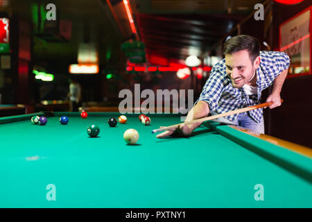 Hansome Mann spielen Pool Bar allein Stockfoto