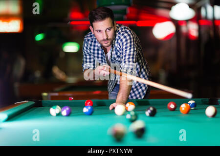 Hansome Mann spielen Pool Bar allein Stockfoto