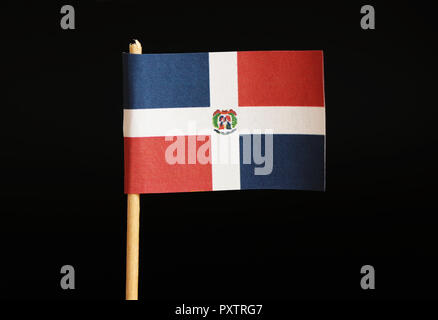 Eine offizielle Flagge der Dominikanischen Republik auf Zahnstocher auf schwarzem Hintergrund. Es ist die Hand, die Flagge ihres Landes vertreten. Dominikanische Republik in Centra entfernt Stockfoto