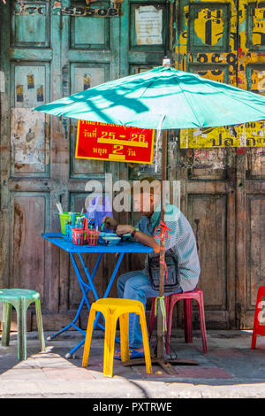 Bangkok, Thailand - 25. September 2018: Mann essen in einem Restaurant Street, Chinatown, Bangkok. Viele Street Food Anbieter einrichten Tische und Stühle. Stockfoto