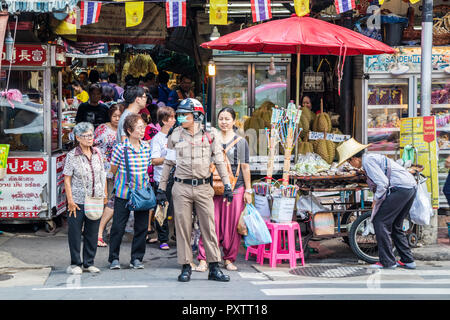 Bangkok, Thailand - 25. September 2018: ein Polizist regelt den Verkehr auf einem Zebrastreifen. Yaowarat Road ist die Hauptverkehrsstraße in Chinatown. Stockfoto