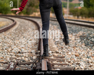 Eine Person, die Balance zu bewahren, zu Fuß entlang der Bahngleise Stockfoto