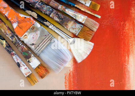 Verschiedene alte Pinsel auf ein abstraktes Gemälde Horizontal Stockfoto