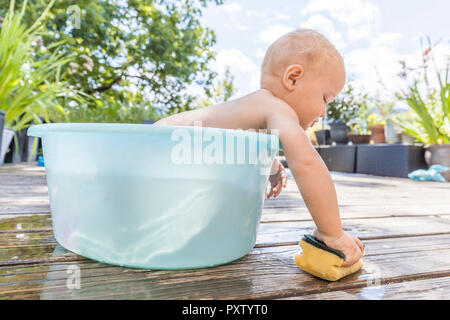 Junge in Baby Badewanne sitzen Stockfoto