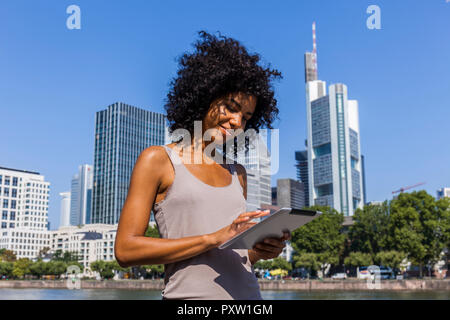 Deutschland, Frankfurt, lächelnden jungen Frau mit Tablet in der Stadt Stockfoto