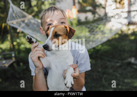 Junge mit Jack Russel Terrier im Garten Stockfoto
