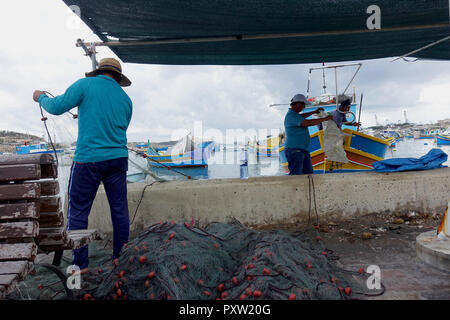 Die Fischer ihre Netze im malerischen Hafen von Marsaxlokk, Malta Stockfoto