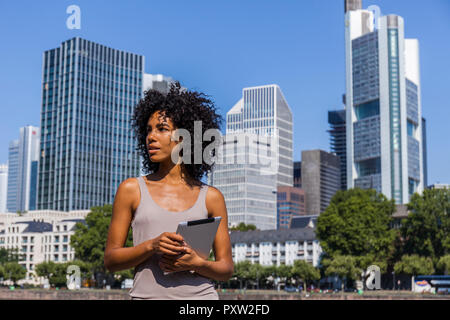 Deutschland, Frankfurt, Porträt der jungen Frau mit Tablet in der Stadt Stockfoto