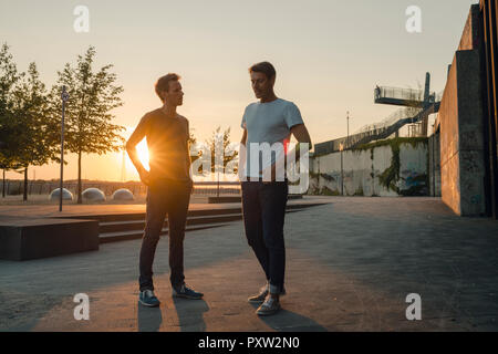 Zwei Freunde treffen bei Sonnenuntergang, am Abend reden Stockfoto