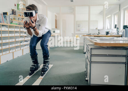 Geschäftsmann Skifahren im Büro, mit VR-Brille Stockfoto