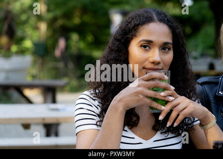 Junge Frau im Biergarten sitzen Stockfoto