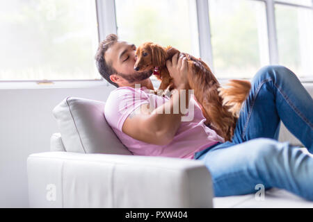 Eine nette Männer auf Sofa mit Hund Stockfoto