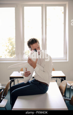 Geschäftsmann spielen mit aufblasbaren Flugzeug im Büro Stockfoto