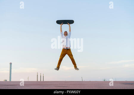 Junge Mann in der Luft mit einem Skateboard springen Stockfoto