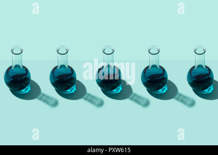 Reihe von Röhrchen mit Flüssigkeit, cyan Hintergrund Stockfoto