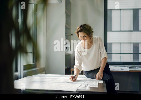 Geschäftsfrau im Büro, arbeiten auf Blueprints Stockfoto