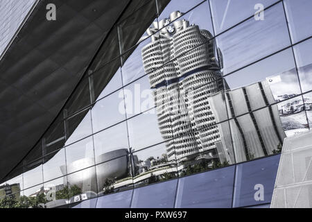 BMW Firmenzentrale spiegelt sich in der Glasfassade der BMW-Welt, München, Bayern, Deutschland, Europa Stockfoto