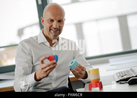 Geschäftsmann spielen mit Spielzeug, Rakete im Büro Stockfoto