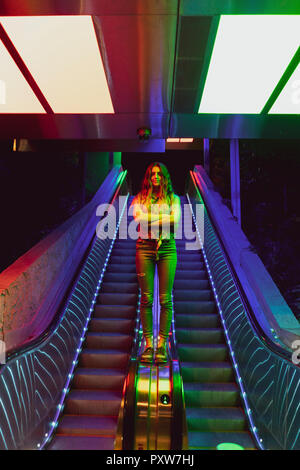 Portrait von beleuchteten junge Frau, Zusatzscheinwerfer auf der Rolltreppe Stockfoto