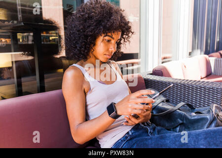 Porträt der jungen Frau an Sidewalk Cafe mit digitalen Tablet sitzen Stockfoto