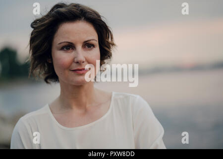 Frau am Fluss in der Dämmerung Stockfoto