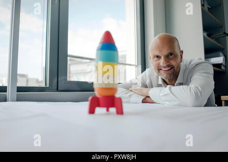 Geschäftsmann spielen mit Spielzeug, Rakete im Büro Stockfoto