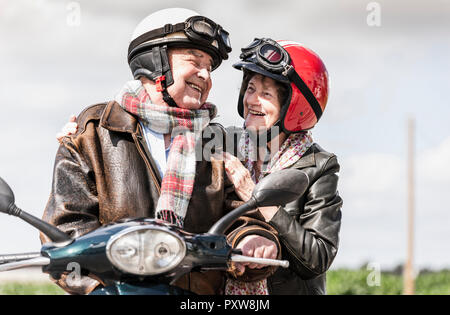 Gerne älteres Paar reiten Motorroller Stockfoto